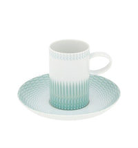 The Venezia Dinnerware coffee cup by Vista Alegre is a white porcelain piece with a handle, decorated with a light green geometric pattern, and comes with a matching saucer featuring the same design.