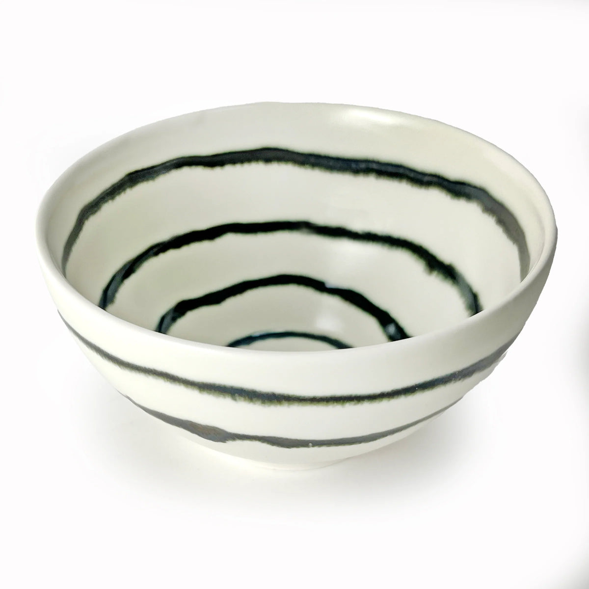 The Michael Wainwright Linea Dip Bowl features uneven, hand-painted black concentric stripes adorning both the interior and exterior of its white ceramic form, shown here against a white background.
