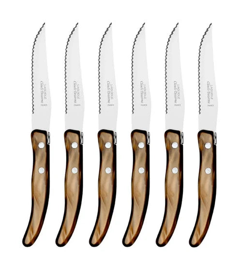 Six identical steak knives from the Claude Dozorme Berlingot Steak Knives Set of 6, each featuring shiny, brownish handles, are arranged side by side with their blades facing up. Known for their exceptional quality, these knives are positioned in a straight vertical row against a white background.