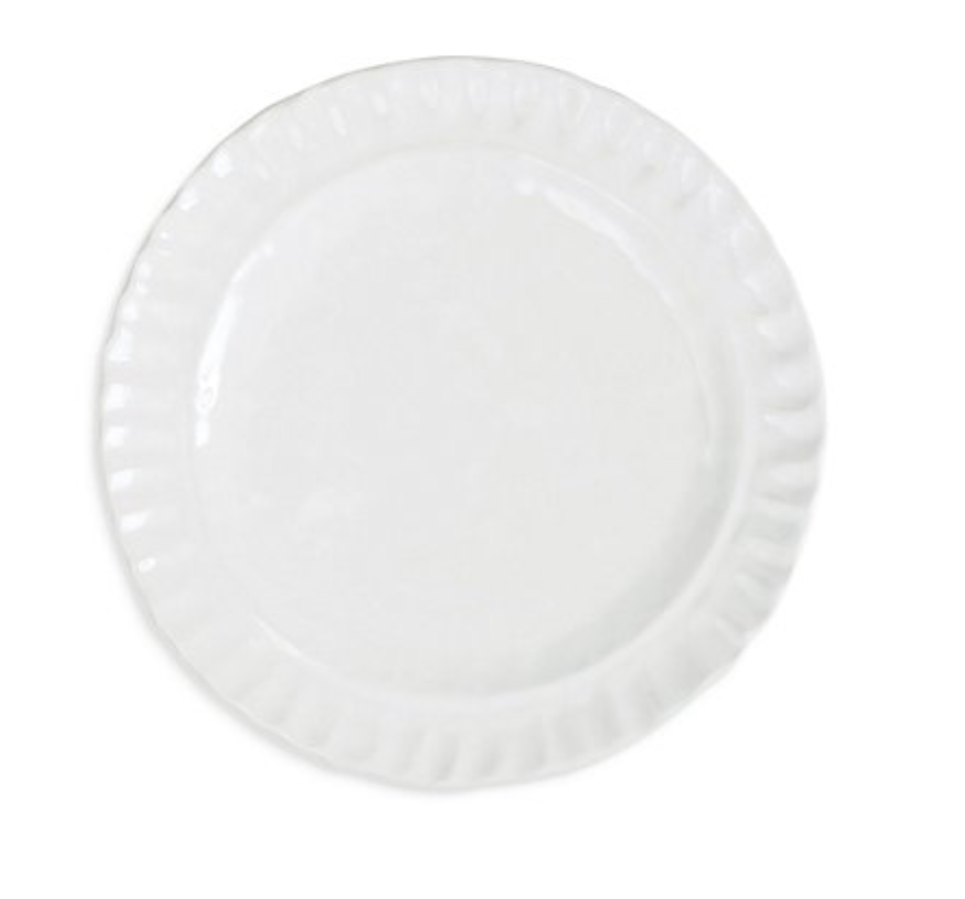 The Vietri Pietra Serena ceramic plate features a plain white design with a slightly scalloped, textured rim—an elegant piece shown from above on a white background, perfect for any white dinnerware set.