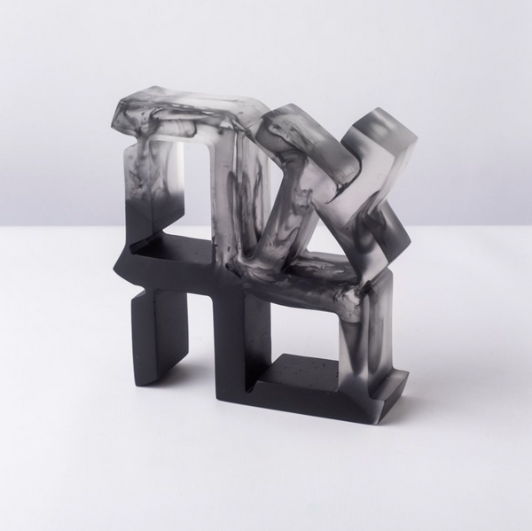 The CDMX / BRUCI Ahava Sculpture - BACK IN STOCK features bold black and white geometric resin forms with smoky marbled patterns, displayed on a white surface for striking visual impact.