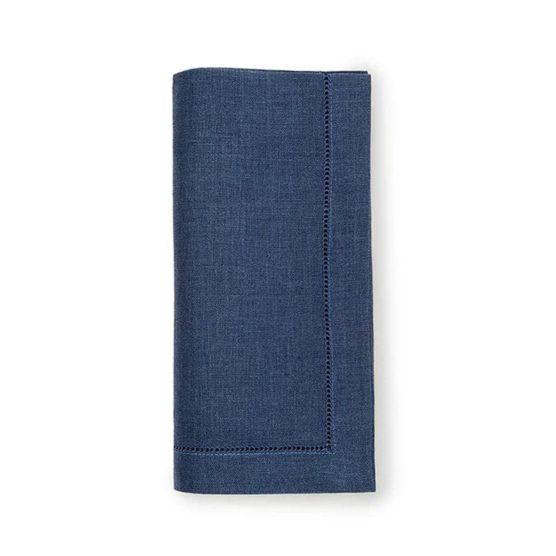 A neatly folded dark blue Festival Napkin from Sferra, featuring stitched edges, is positioned vertically against a plain white background.