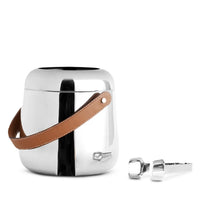 The Nambe Tahoe Ice Bucket w/ Tongs features a sleek stainless steel body with a brown leather handle and matching silver tongs—a stylish, modern addition to your home bar accessories.