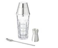 The Saint-Louis/Hermes Manhattan Mixology Set includes a clear glass shaker with a polished silver cap, matching jigger, and long spoon—an elegant bartender’s set stylishly showcased against a white background.