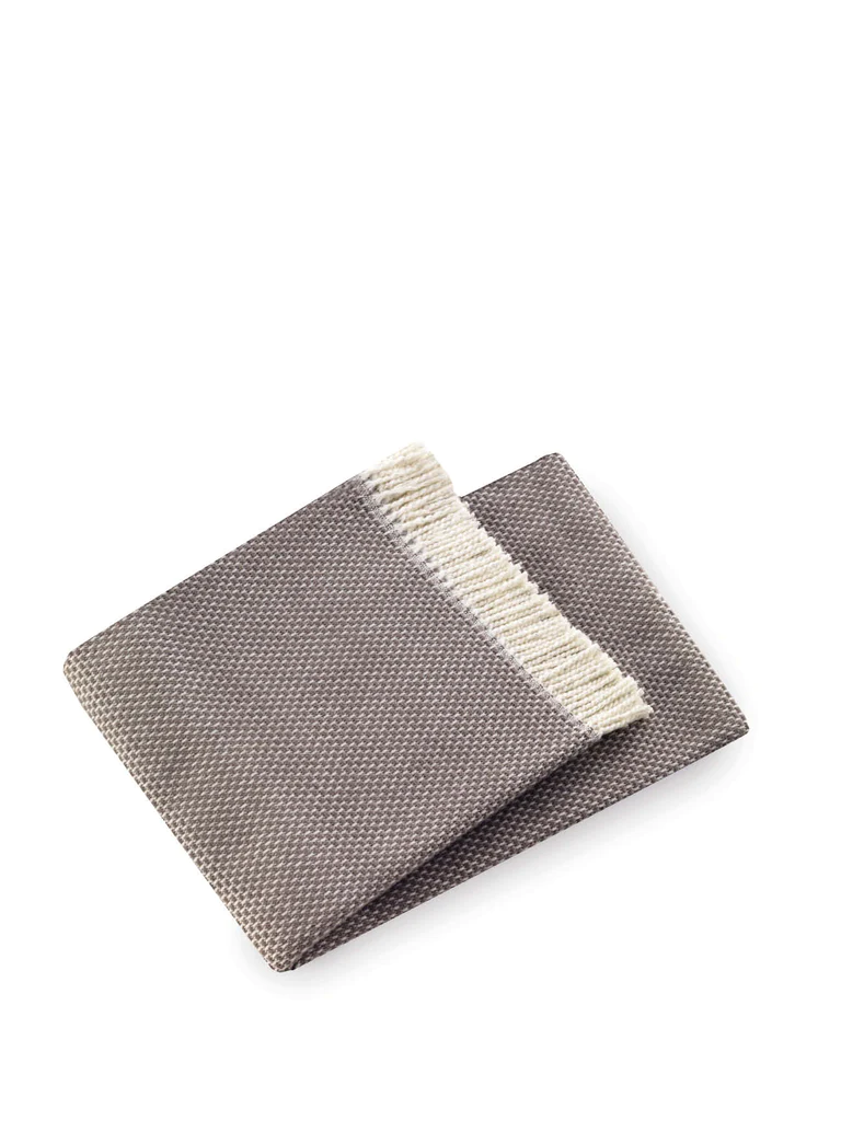 The Grain of Rice Throw by A Soft Idea is a super soft, textured brown blanket with a cream fringe, shown on a white background and conveniently machine washable.