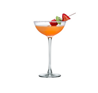 A vibrant orange cocktail with a sugared rim is served in a Hepburn Coupe Glass by Nude Glassware, garnished with strawberry and kiwi slices on a skewer. The glass is crafted from lead-free crystal and set against a plain white background.