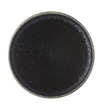 The Tourron Dinnerware Celeste by Jars - Rosenthal is a round, black glazed stoneware plate with a speckled texture and lighter rim, shown from above on a white background. This artisanal ceramic piece is stylish and dishwasher safe.