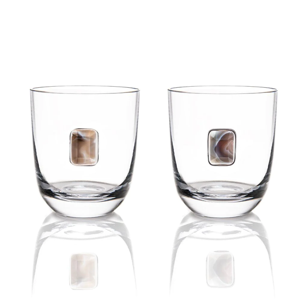 The Elevo DOF Glasses Smoke Set of 2 by Anna New York features lead-free crystal glasses with a rectangular stone embedded in each side, displayed on a white background with reflective surfaces.