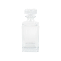 The Vietri Natalia Decanter, an Italian glass decanter with a square base and matching stopper, is perfect for elevating your bar. Shown against a plain white background.