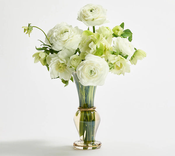 The Kim Seybert Champagne Rib Gold Detail Vase, made from clear mouth-blown glass, is shown filled with white and pale green roses and ranunculus against a plain white background.