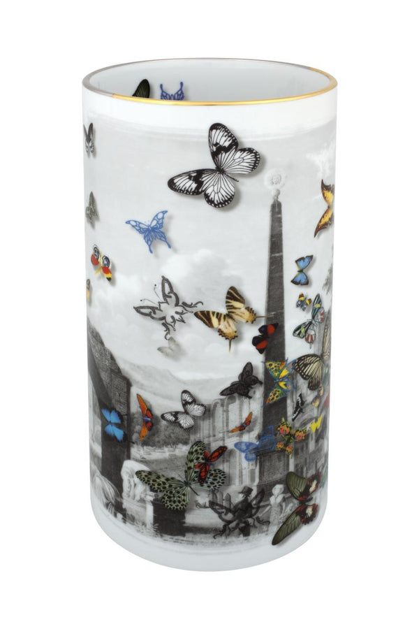 The Large Forum Vase by Christian Lacroix for Vista Alegre is a cylindrical porcelain piece adorned with a striking black-and-white cityscape, accented by colorful butterflies of varying sizes fluttering across its surface. This artistic vase seamlessly blends modern design with timeless elegance, capturing the distinctive style of Christian Lacroix.