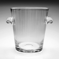 The Corinne Ice Bucket by William Yeoward is a clear glass bucket with vertical ribbed lines and two small rounded side handles, shown against a gradient gray background.
