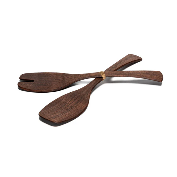 The Andrew Pearce Wood Servers Walnut - Medium set features one forked and one solid utensil, crossed and secured with a small band. Food-safe and stylish, these servers complement any wooden salad bowl.