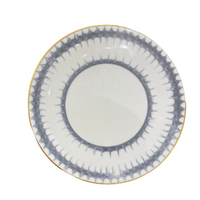 The Marie Daâge Rafia 5 Dinnerware by Marie Daâge is a round white porcelain plate featuring a gray spiked radial border and thin gold rim, hand-painted in France to add elegance to your tableware collection.