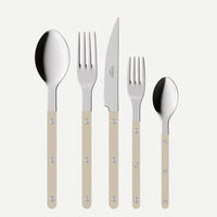 The Bistrot Solid Flatware 5 Piece Setting - Shiny by Sabre features beige-handled utensils—a large spoon, dinner fork, steak knife, salad fork, and small spoon—elegantly displayed side by side on a white background.