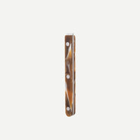 A long, rectangular Sabre Bistrot Flatware 5 Piece Set - Buffalo cutlery piece with a brown marbled handle featuring three evenly spaced round white holes, shown against a plain white background.