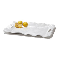White wavy ceramic tray with lemons on a white background