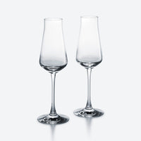 Two clear, empty Baccarat Chateau Barware crystal glasses with slightly flared rims stand side by side on a plain light gray background.