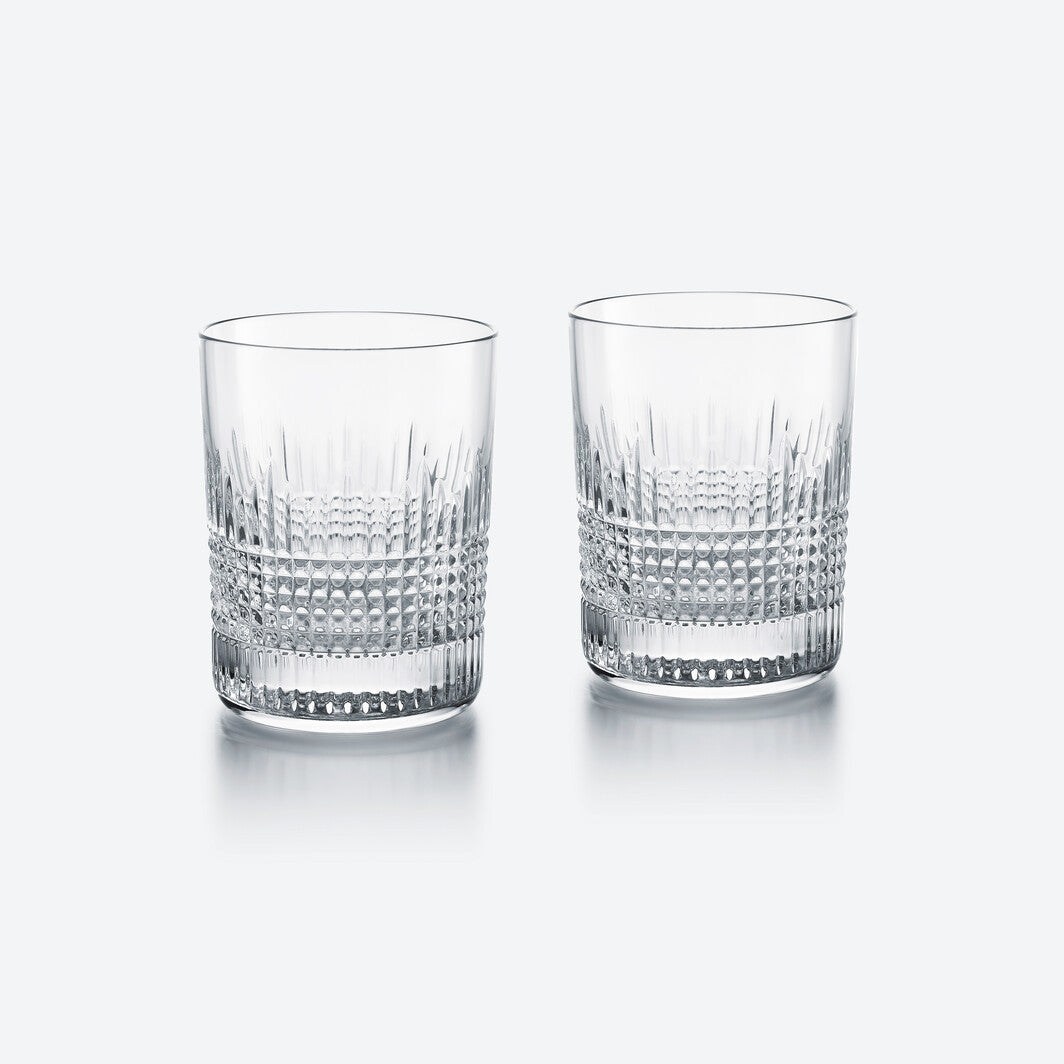 The Baccarat Nancy Barware Set of 2 includes clear crystal tumblers with geometric cut patterns, shown side by side on a light gray background.