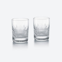The Baccarat Nancy Barware Set of 2 includes clear crystal tumblers with geometric cut patterns, shown side by side on a light gray background.