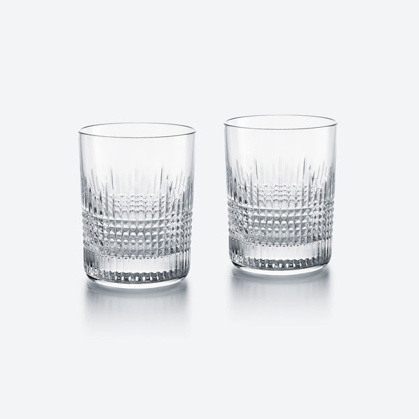 The Baccarat Nancy Barware Set of 2 includes clear crystal tumblers with geometric cut patterns, shown side by side on a light gray background.