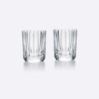 The Baccarat Harmonie Barware Set of 2 features clear highball glasses with vertical cuts, placed side by side on a light gray background, highlighting the refined modern design of these signature Baccarat glasses.