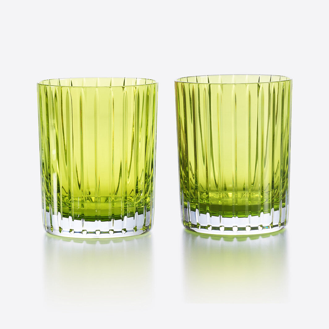 Two Baccarat Harmonie Colors of Joy S/2 tumblers in Moss, featuring vertical ridges, sit side by side on a reflective surface against a white background.