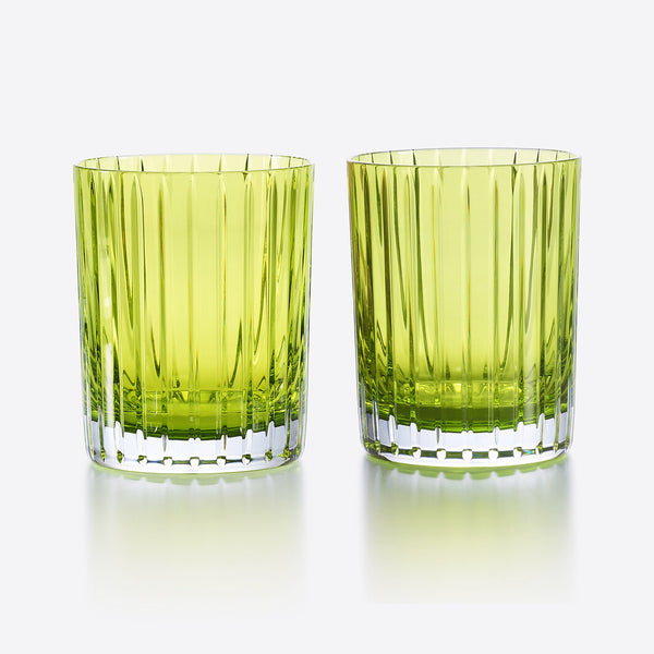 Two Baccarat Harmonie Colors of Joy S/2 tumblers in Moss, featuring vertical ridges, sit side by side on a reflective surface against a white background.