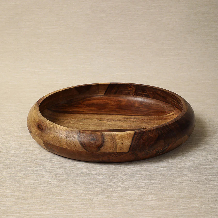 The Be Home Rosewood Low Bowl is a 13.5-inch salad bowl featuring a smooth polished finish and natural wood grain, crafted from quality rosewood and displayed on a neutral beige surface.