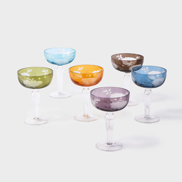 The Polspotten Peony Coupe Glass Multi Set of 6 features vintage-style colored glasses with etched white floral and sandblasted patterns in green, blue, orange, brown, purple, and teal, shown grouped on a plain white background.