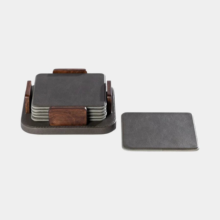 The Zodax Leather & Veneer Coaster Set - Cedar Green features square coasters with a wood holder. One coaster sits outside the holder, which contains more coasters, all against a plain light background.