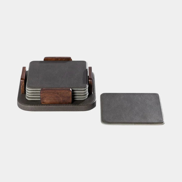 The Zodax Leather & Veneer Coaster Set - Cedar Green features square coasters with a wood holder. One coaster sits outside the holder, which contains more coasters, all against a plain light background.