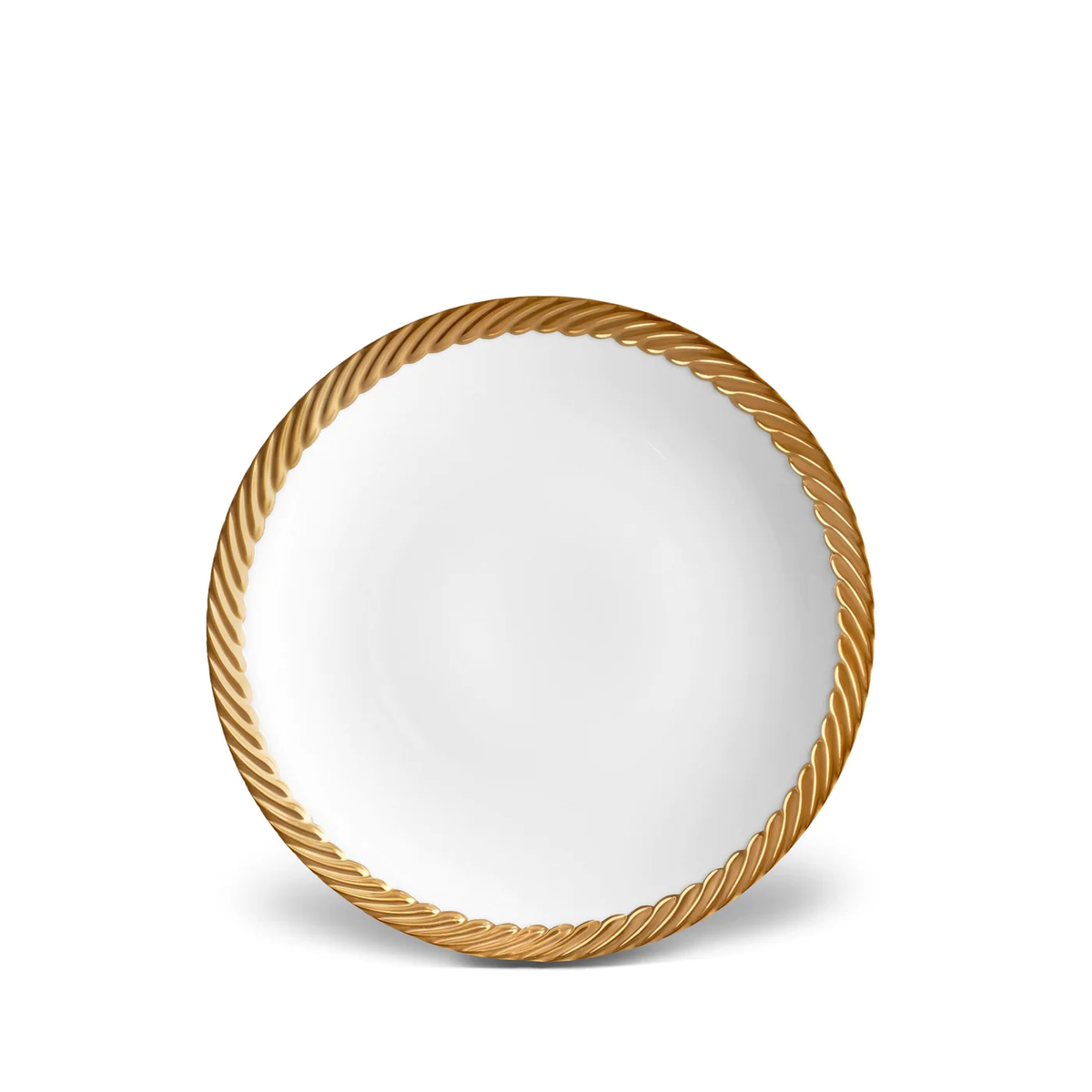 The Corde Dinnerware Gold plate from L'Objet, featuring a white base and textured gold rim, showcases modern dining style and the elegance of hand-painted craftsmanship.