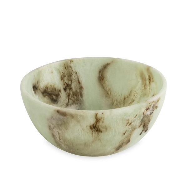 The Beatriz Ball Resin Giada Bowl Jade Swirl - Large features a round, shallow design inspired by jade, crafted in light green onyx-like resin with natural-looking brown and tan marbling patterns throughout its surface, showcasing a unique color pattern as it rests on a white background.