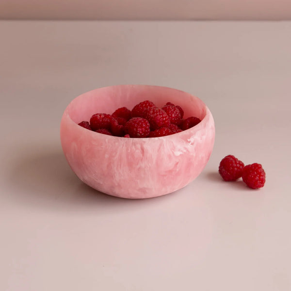 The Beatriz Ball Resin Sorbet Mini Bowl - Raspberry, filled with fresh raspberries and set on a light surface with extra berries beside it, makes an ideal hostess gift.