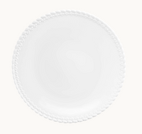 The Babylone Dinnerware by Christofle features a white porcelain dinner plate with a raised braided edge pattern, photographed from above on a light background. This elegant French-made piece is inspired by the Babylone collection.