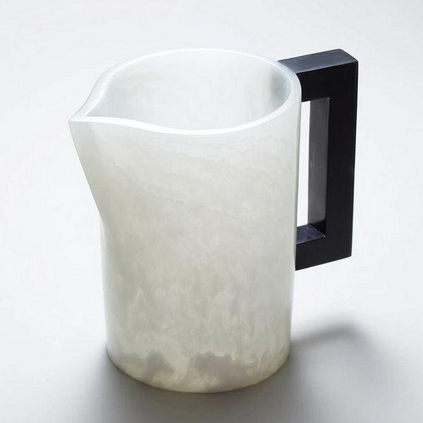 The Pearl's Pitcher White with Charcoal Handle by Lily Juliet features a translucent, marbled white resin body and a geometric black handle, offering modern elegance for dinner parties. Its matte finish sits beautifully on any light surface.