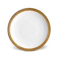 The L'Objet Corde Dinnerware Gold is a white plate with a textured, twisted rope-like gold rim, seen from above on a plain background—an elegant addition to any modern table setting.