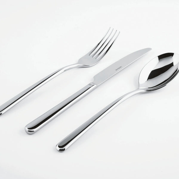 The Sambonet Linear Solid Handle Flatware 5 Place Setting—featuring sleek modern design—is artfully displayed side by side on a white surface.