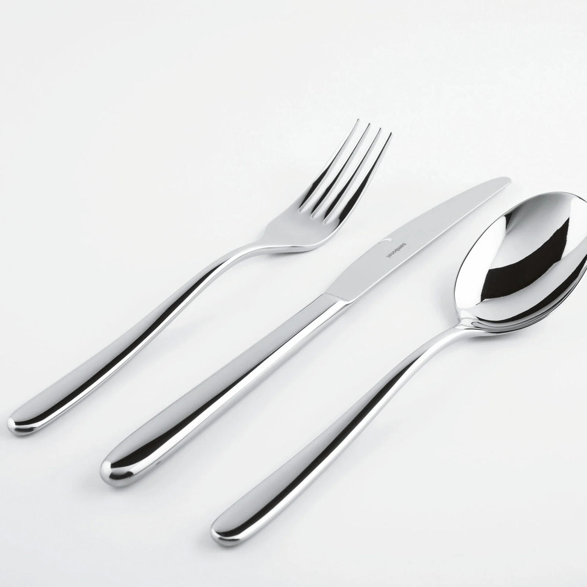 The Sambonet Hannah Flatware 5 Piece Setting in stainless steel is displayed with its pieces—a fork, knife, and spoon—neatly arranged side by side on a plain white background.