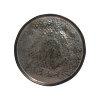 The Costa Nova Lagoa Dinnerware plate features round stoneware with a metallic-look, hammered texture, raised rim, and shiny mottled dark gray and silver finish. Photographed from above on white. Made in Portugal.
