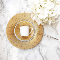A white teacup rests on a Haviland Infini Prestige Gold Dinnerware saucer and plate atop a marble surface, beside a bouquet of white hydrangeas.