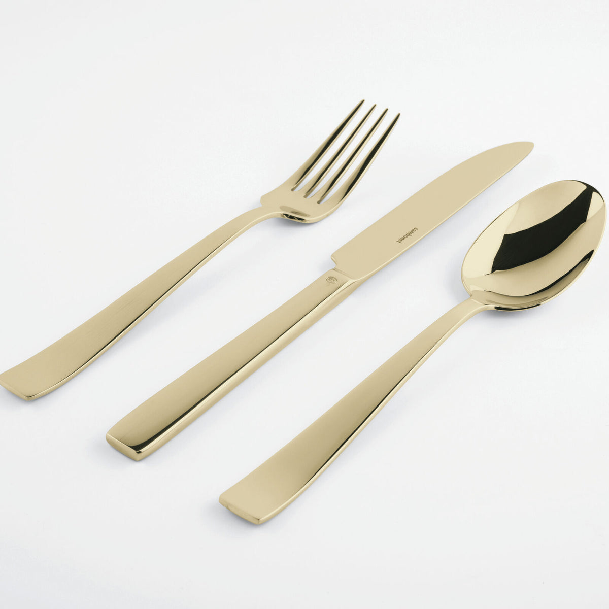 The Sambonet Flat PVD Flatware 5 Piece Setting in Champagne is shown with the fork, knife, and spoon arranged side by side on a white background.