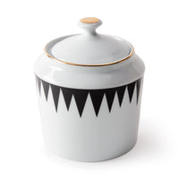 The Molecot Punk Dinnerware white ceramic jar features a lid with black zigzag detailing and gold-accented handle and rim, bringing modern style to any table setting.