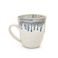 The Simon Pearce Burlington Dinnerware Pool ceramic mug features a square rim, white base, and blue-gray drip glaze at the top—a unique pottery piece perfect for your dinnerware collection.