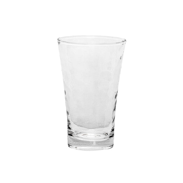 The Juliska Puro Glassware is a clear, empty glass with a textured surface and slightly flared rim, shown upright on a white background. Dishwasher safe for easy cleaning.