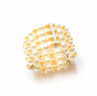 The Pearl Cuff Napkin Ring Gold Set of 4 by Von Gern Home features alternating white and gold pearl beads with three parallel silver bars, perfect for elegant table settings. Displayed on a white background.