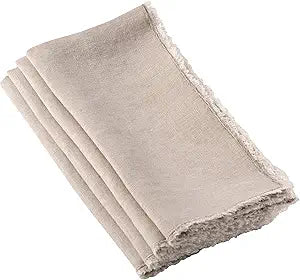 The Saro Trading Fringed Napkin Natural Set of 4 features machine-washable, stone-washed beige linen napkins with frayed edges, neatly folded and displayed on a white background.