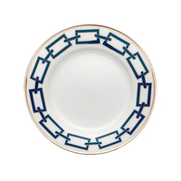 The Catene Zaffiro Dinnerware by Ginori 1735 is a white porcelain plate with a blue rectangular chain pattern and a gold rim, inspired by Gio Ponti, shown on a white background.
