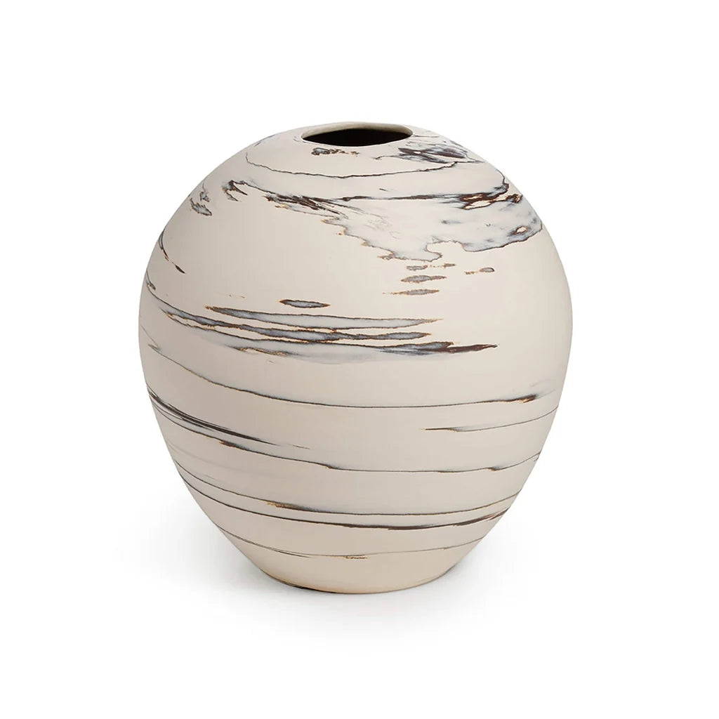 Beachstone Vase Sand by Simon Pearce: A round, off-white ceramic vase with a small opening at the top and abstract brown and gray marbled streaks accenting its hand-thrown surface. This artisan piece is a stunning addition to any pottery collection. Displayed on a plain white background.